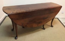 A modern oak oval dining or wake table in the Georgian style raised on cabriole legs to pad feet