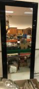 A modern black framed rectangular wall mirror,