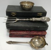 A collection of various small silver wares to include two sets of six teaspoons, tea strainer,