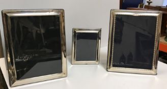 Three various modern rectangular silver sheathed easel back photograph frames, 18.5 cm x 23.
