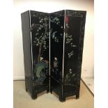 A 20th Century Japanese carved and painted black lacquered four fold screen decorated with bird