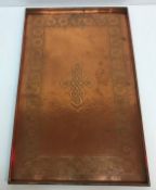 A large rectangular Keswick style copper tray with embossed foliate decorated border and knot