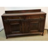 An early 20th Century oak dresser with shallow raised back over two drawers and two panelled