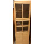 A modern beech veneered cabinet with two glazed doors over two banks of four short drawers 73 cm