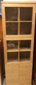 A modern beech veneered cabinet with two glazed doors over two banks of four short drawers 73 cm