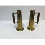 A pair of brass vases of cylindrical tapering form to flared circular base each set with a handle