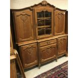 An oak side cabinet in the 18th Century style the upper section with glazed and barred door