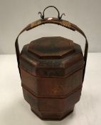 A South East Asian octagonal food container with cane work and metal handle and painted / gilded