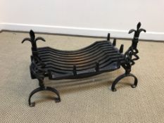 A cast iron log basket 61 cm long and fire dogs 46 cm high with open barley twist and fleur de lys