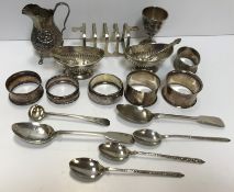 A collection of small silver wares to include a pair of reeded salts, embossed cream jug,