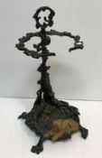 A cast iron painted stick stand set with dog decoration to base and gun and horn to back support 55