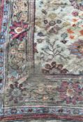 An Indian carpet, the central panel set with floral design on a cream ground,