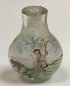 A Chinese glass flask shaped snuff bottle decorated with woman by tree and woman in a garden