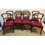 A set of eight Victorian mahogany kidney back dining chairs with drop in seats on turned and carved