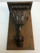 A carved oak corbel with stylised foliate decoration mounted on a wooden back, total size 41.