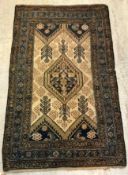 A Persian rug, the central panel set with lozenge shaped medallion on a cream ground,