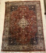 A Persian rug, the central panel set with floral decorated medallion on a brown ground,