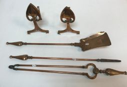 An Arts & Crafts style copper fire companion set comprising poker, shovel and tongs and fire dogs,