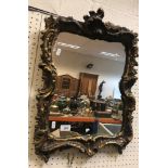 A pair of 19th Century giltwood and gesso wall mirrors in the Rococo manner with C scroll and shell