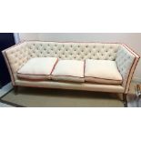 A Lawson Wood cream buttoned knowle style three seat sofa with scarlet velvet piping,