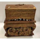 A Burmese carved and gilded wooden dome top miniature trunk on stand,