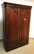 A Victorian mahogany two door wardrobe with hanging space over three drawers on a plinth base 135