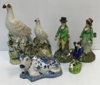 A pair of early 19th Century Staffordshire figures of a gentleman with gun and woman with bow and