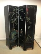 A 20th Century Japanese carved and painted black lacquered four fold screen decorated with bird