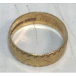 An 18 carat gold wedding ring with engraved decoration 3.