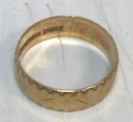 An 18 carat gold wedding ring with engraved decoration 3.