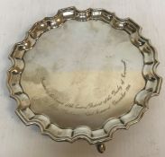 WITHDRAWN A silver card tray with pie crust edge and raised on three hoof feet inscribed "Presented