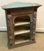 A carved and limed oak hanging corner cupboard in the 17th Century Flemish manner,