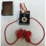 A Japanese Order of the Rising Sun medal on white and red ribbon with polished garnet suspended