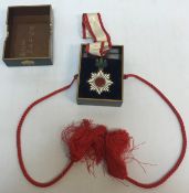 A Japanese Order of the Rising Sun medal on white and red ribbon with polished garnet suspended