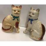 Two pottery cats, one wearing a green bow, the other blue, 20.