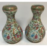 A pair of 19th Century Chinese famille rose gourd shaped vases painted with panels of figures in