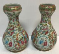 A pair of 19th Century Chinese famille rose gourd shaped vases painted with panels of figures in