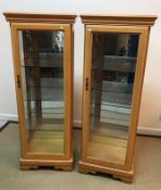 A pair of modern beech veneered vitrines or display cabinets with single bevel edge glazed doors