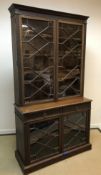 An Edwardian mahogany bookcase cabinet with blind fretwork decoration,