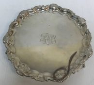 An Edwardian silver card tray with shell and scrolling pie crust edge raised on three claw and ball