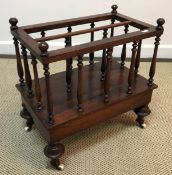 A Victorian rosewood two section canterbury with baluster turned supports on turned cup and cover