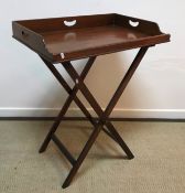 A mahogany and brass bound butlers tray of typical form on folding stand 71 cm x 47 cm