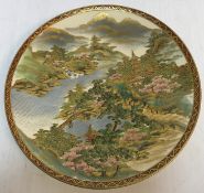 A 20th Century Japanese koshida satsuma plate decorated with a lakeland montainous landscape with