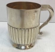 A silver Christening mug with gilt wash interior and half reeded decoration to base (London,