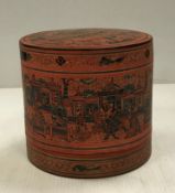 A Burmese red lacquered cylindrical betel box with script to front 21 cm diameter x 19.