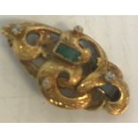 A 19th Century yellow metal brooch of entwined scrolling form set with four diamonds and a baguette