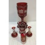 A 19th Century ruby overlaid cut glass oversized goblet decorated with town scene panels including