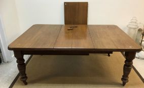 A late Victorian oak extending dining table, the rounded rectangular top with two extra leaves,