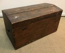 A Victorian stained pine dome top trunk with twin locking mechanism and iron side handles,