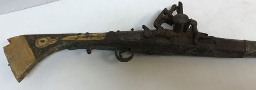 A 19th Century Indian flintlock musket with white metal embellishments and bone inlaid decoration